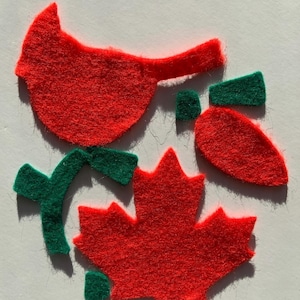 May include: A collection of red felt shapes, featuring a bird, maple leaf, and carrot, with green details. These craft pieces are suitable for various DIY projects and seasonal decorations.