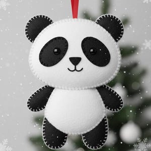 May include: A handmade panda bear ornament with a red ribbon for hanging. The plush panda is white with black accents on the ears, eyes, and limbs. The ornament is stitched with white thread and has a smiling face.