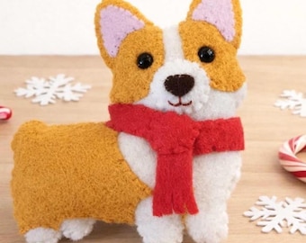 May include: A felted Corgi dog figurine featuring golden-yellow and white fur, black bead eyes, and a dark brown nose. The dog is wearing a bright red felt scarf around its neck. The figure has pointed ears with light pink inner accents.