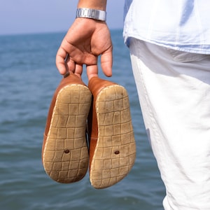 Slip-on convenience combined with barefoot engineering and grounding intent.