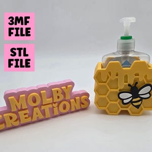 Puede incluir: Un soporte amarillo en forma de panal con un diseño de abeja en blanco y negro, que sostiene una botella transparente con una bomba blanca. El soporte está junto a un letrero rosa y amarillo que dice "MOLBY CREATIONS". También hay letreros rosas y blancos que dicen "3MF FILE" y "STL FILE".