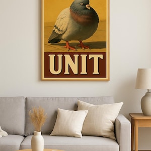 May include: A framed print featuring a detailed illustration of a pigeon. The bird has gray, white, and red plumage, with the word "UNIT" in bold letters at the bottom. The artwork is set against a warm, neutral background.
