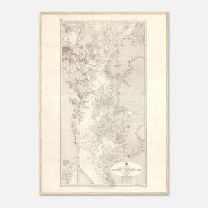 May include: A vintage-style nautical chart of the Chesapeake Bay printed in sepia tones on a light background. The map features detailed hydrographic data, compass roses, and text reading Chesapeake Bay, Cove Point to Susquehanna River.