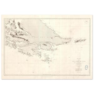 May include: Antique map print of Tierra del Fuego, featuring detailed coastlines and geographical features. The map is printed on aged paper with a grid overlay and includes text in Spanish. A blue seal is visible in the lower right corner.