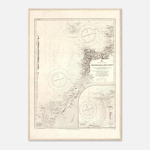 Op de afbeelding: Een ingelijste vintage zeekaart getiteld "Trevor Head to Bull Point". De kaart, in een licht houten frame, toont kustlijnen, kompasrozen en dieptemetingen, in beige en grijstinten.