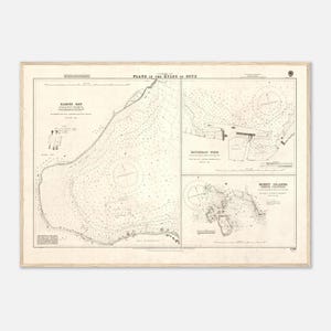 May include: A detailed vintage nautical chart titled "Plans in the Kyles of Bute", featuring Rames Bay, Rothesay Pier, and Burnt Islands. The map has intricate line work and text, framed in a light wood.