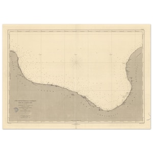 May include: A vintage nautical map print featuring a detailed coastal outline, with numerous small dots indicating depth. The map is in sepia tones, with text in French. The map includes a compass rose and grid lines.