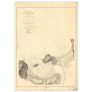 Peut inclure: Une ancienne carte nautique de la Baie de St. Sébastien, avec des côtes détaillées, des sondages et des noms de lieux. La carte est imprimée à l'encre noire sur du papier vieilli, avec du texte en français. La carte comprend une échelle et d'autres détails cartographiques.