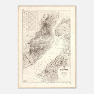 May include: A framed vintage nautical chart of Kyle Rhea, Scotland, in a light wood frame. The map shows detailed topographical lines, depth soundings, and the text "Kyle Rhea, Sound of Sleat". The chart is in shades of beige and brown.