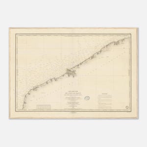 May include: An antique nautical map of the French coast, featuring detailed cartography and text. The map is framed in a light wood frame, with a cream-colored background and black text. The map shows the coastline and includes various geographical details.
