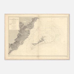 May include: Antique nautical chart of the Bay of Cadiz, Spain, with detailed coastlines and sea depth markings. The map is printed in black and white on aged paper, featuring text in the upper left corner. The chart is framed with a decorative border.