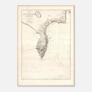 May include: Vintage nautical chart of Ensenada de Finisterre, with detailed coastal features and depth soundings. The map is framed in light wood, displaying historical cartography with a classic aesthetic.