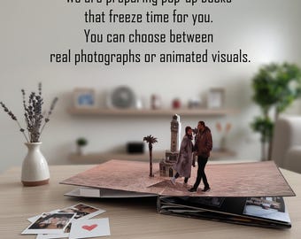 May include: An open pop-up book with a miniature scene of a couple and a tower. The book is on a wooden table with photos and a vase of lavender. Text on the image reads: "We are preparing pop-up books that freeze time for you."