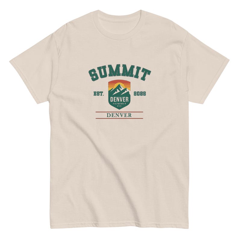 K&ouml;nnte beinhalten: Cremefarbenes T-Shirt mit einem Grafikdesign. Das Design enth&auml;lt das Wort "SUMMIT" in gr&uuml;nem, bogenf&ouml;rmigem Text, eine Berglandschaft und den Text "DENVER" und "8088". Das T-Shirt hat einen Rundhalsausschnitt und kurze &Auml;rmel.