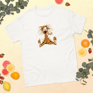 May include: White t-shirt featuring a cartoon illustration of an orange cat with the word "ACK!" printed above it. The cat is depicted with a surprised expression, tongue out, and arms and legs spread.