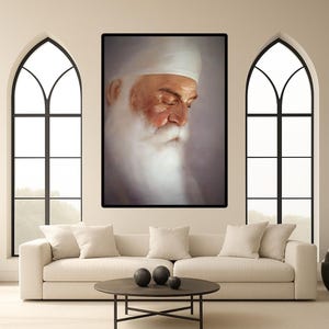 May include: A framed portrait of a man with a long white beard and a white turban. The painting is displayed above a white sofa with several pillows. A round coffee table with black spheres sits in front of the sofa.