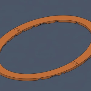 May include: An orange, oval-shaped object with a notched edge and two interlocking sections. The object is set against a dark blue-gray background. The design appears to be a component or part.