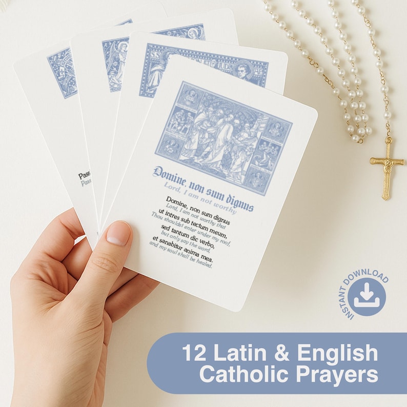 May include: A hand holds a stack of white prayer cards with blue illustrations and text. The cards feature Latin and English text, including "Domine, non sum dignus." A rosary with a gold cross hangs in the background. The text at the bottom reads "12 Latin & English Catholic Prayers."