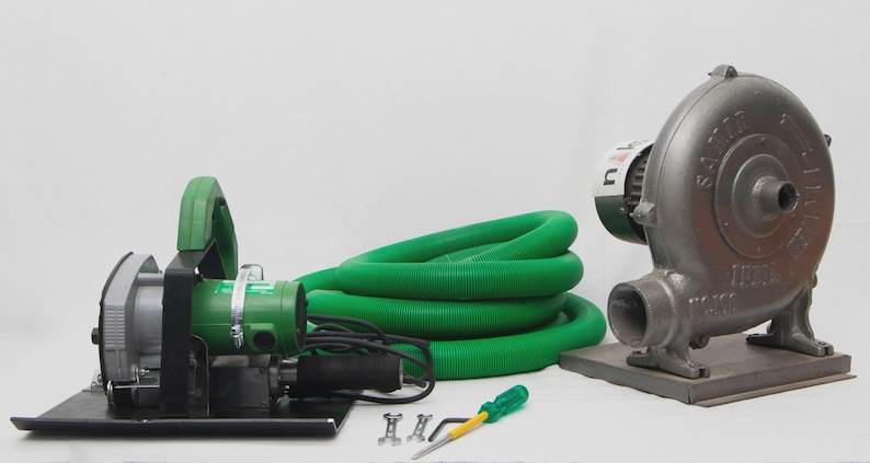 May include: An assortment of industrial equipment, including a green and silver power tool with a handle, a coiled green hose, and a gray blower fan. A screwdriver and small hardware are also present.
