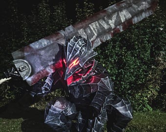 Könnte beinhalten: Eine Ganzkörper-Plattenrüstung in dunkler, verwitterter Optik mit einem spitzen Helm und leuchtend roten Augenschlitzen. Die Rüstung kauert und trägt ein massives, rechteckiges, blutbeflecktes Großschwert auf den Schultern.