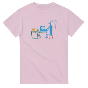 Puede incluir: Camiseta rosa claro con una ilustración caprichosa y colorida. El diseño representa a una persona sentada en un escritorio con una computadora, representada en azul, rojo y verde. El escritorio tiene un cajón y algunos objetos encima.