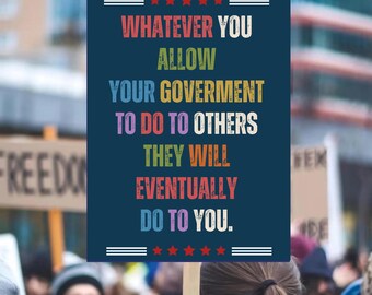 May include: A navy blue sign with the text "WHATEVER YOU ALLOW YOUR GOVERNMENT TO DO TO OTHERS THEY WILL EVENTUALLY DO TO YOU." The sign has red stars and white lines at the top and bottom. The sign is held up in a crowd.
