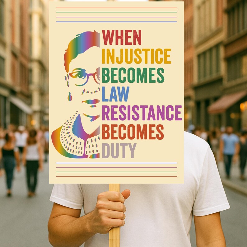May include: A rectangular sign with a cream background featuring a rainbow-colored portrait of Ruth Bader Ginsburg on the left and the text "WHEN INJUSTICE BECOMES LAW RESISTANCE BECOMES DUTY" in multi-colored capital letters on the right side.