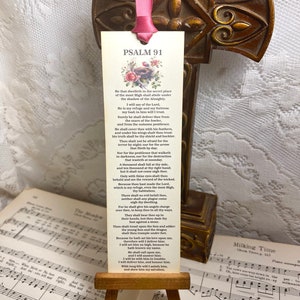 May include: A bookmark with a white background and floral design. The bookmark features the text "Psalm 91" and a passage from the Bible.