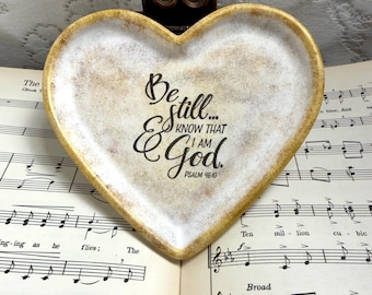 Plato de cemento con forma de corazón, versículo del Salmo 46:10, decoración cristiana con aspecto envejecido y desgastado.