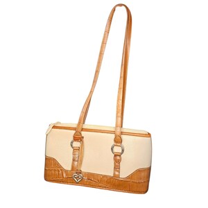 May include: Cream-colored rectangular handbag with brown crocodile-textured accents and a long strap. The bag features silver-tone hardware, a heart-shaped charm, and a zipper closure. The strap is approximately 24 inches long.