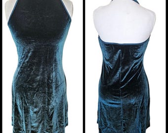 May include: A teal blue velvet halter dress with a fitted bodice and a flared skirt.