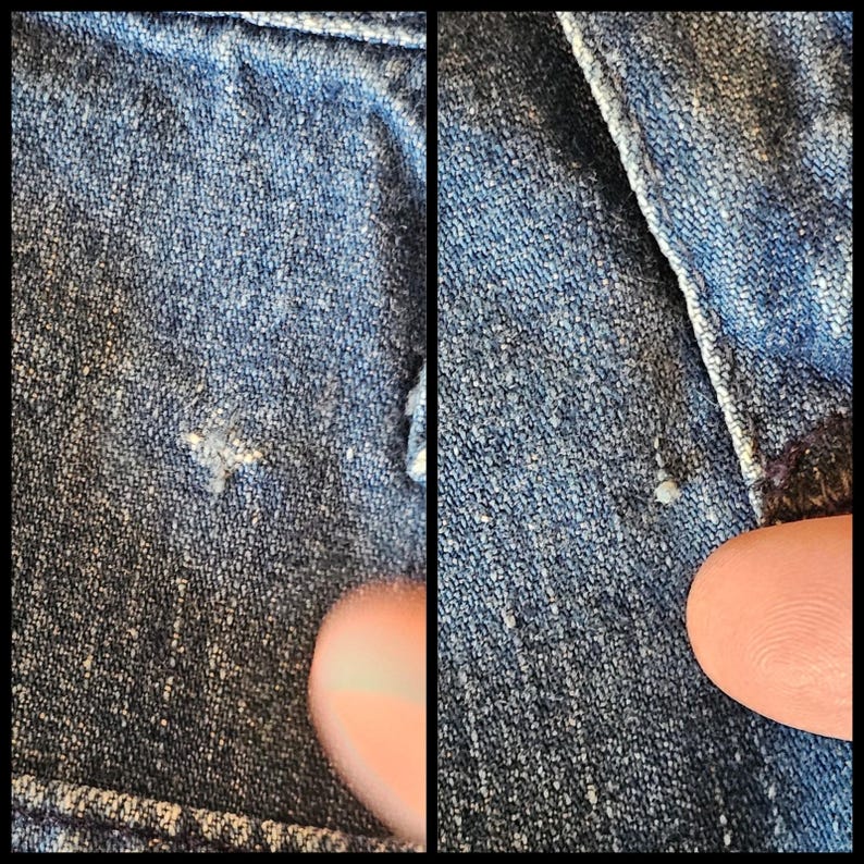May include: Close-up of two sections of blue denim fabric. The fabric has a textured appearance with small, light-coloured flecks. A finger is visible in the lower right corner of the second section, providing scale. The denim appears to be from a jacket or trousers.