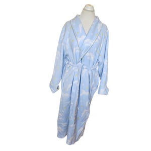 May include: A light blue robe with a cloud and star pattern. The robe has a shawl collar, long sleeves, and a matching belt. The trim is a light gray color.