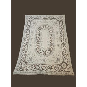 May include: A white ceramic mug with a black handle and the text "But First, Coffee" in a black, handwritten-style font. The mug is on a white surface.