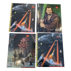 May include: Four Star Wars themed notebooks with different characters and scenes. The notebooks are black with red and yellow accents. The text on the notebooks reads "Star Wars" and "Jedi".
