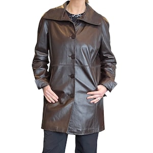 May include: A brown leather jacket with a collar and five buttons down the front.