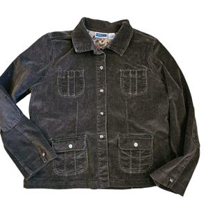 May include: A brown corduroy jacket with a button-up front and multiple pockets. The jacket has a floral patterned lining and a label that reads "Liberty & Co."