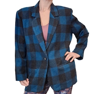 May include: A blue and black plaid blazer with a single button closure. The blazer has a notched collar and flap pockets.