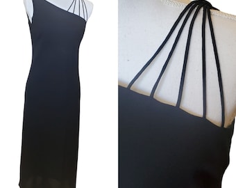 May include: Black one-shoulder dress with a criss-cross strap detail on the shoulder.