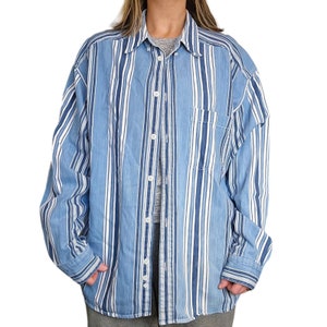 May include: A blue and white striped long-sleeved button-down shirt with a chest pocket.
