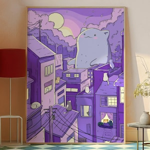 May include: A framed art print with a whimsical illustration of a giant cat overlooking a city. The artwork is dominated by shades of purple and depicts cats on rooftops and in windows. The sun and clouds are visible in the background.