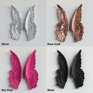 four different colored angel wings, each labeled with a color name: silver, rose gold, hot pink, and black.