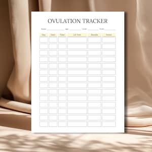 May include: A white Ovulation Tracker sheet with a grid for tracking cycles. The title "OVULATION TRACKER" is at the top. The sheet includes sections for name, age, cycle, and LH test results. The background is a neutral beige.
