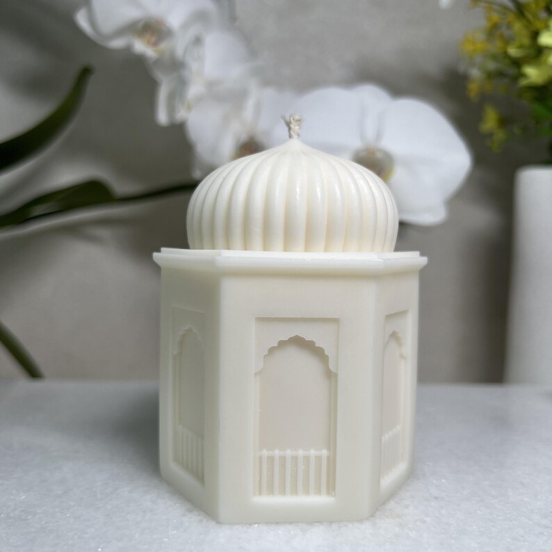 einer Moschee Kerze aus pflanzlichem Rapswachs.Die handgefertigte Skulpturkerze zeigt eine kuppelförmige Struktur,dezente architektonische Details.Perfekt als Ramadan islamische Dekoration,als liebevolles Geschenk zu Eid.harmoniert mit verschiedenen Einrichtungsstilen.Seitliche Ansicht einer hohen islamischen Moschee Kerze mit klaren Linien und minimalistischer Form.duftfrei und ungefärbt.Geeignet als moderne Ramadan Dekoration, islamische Deko für das Wohnzimmer, als hochwertiges zu Eid Mubarak