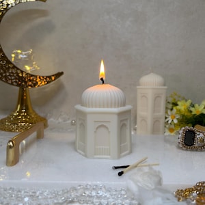 Elegante Präsentation einer Moschee Kerze als Teil eines Ramadan Kerzen Sets. Die Kombination aus natürlichem Wachs, schlichter Farbgebung und orientalischer Architektur macht diese Kerze zu einer zeitlosen islamischen Dekoration. Ideal für festliche Anlässe, Gebetsbereiche oder als besonderes islamisches Geschenk.