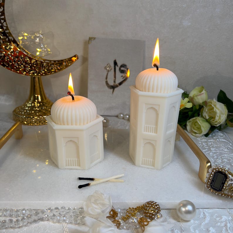 Elegante Ramadan Dekoration mit Moschee Kerzen Set aus Wachs, bestehend aus einer hohen Turmkerze und einer kompakten Kuppelkerze. Orientalische Fensterformen, sanfte Farben, kombiniert mit Halbmond-Deko und Blumen. Ideal für islamische Tischdeko, Wohnzimmer oder als Ramadan Geschenk.Große Moschee Kerze mit detailreicher Kuppel und architektonischen Elementen. Diese handgemachte Ramadan Kerze aus veganem Rapswachs ist ein elegantes Highlight für islamische Wohnkultur.