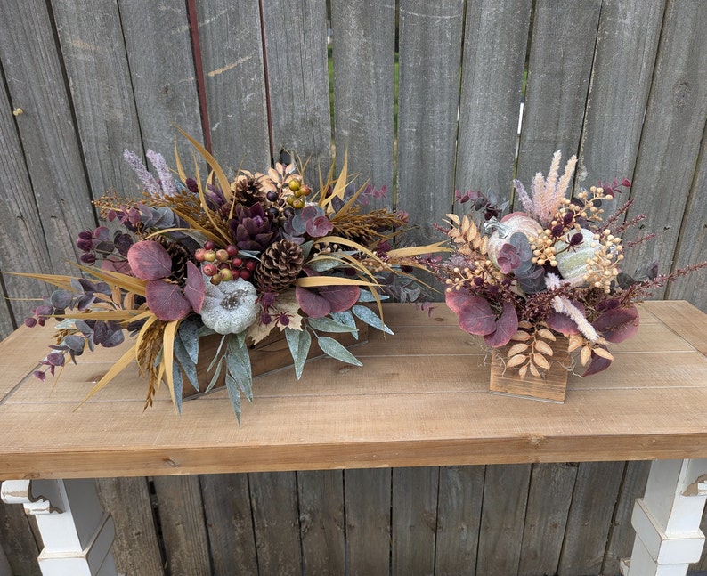 Box arrangements in burgundy and purple with pumpkins