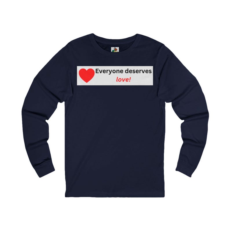 Front view of a navy blue long-sleeve t-shirt with a white rectangular graphic on the chest that displays a red heart and the text Everyone deserves love!.