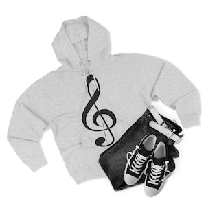 A grey zip-up hoodie with a treble clef next to black and white canvas sneakers and dark jeans.
