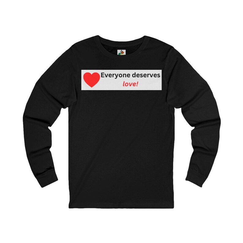 Front view of a black long-sleeve t-shirt with a white rectangular graphic on the chest containing a red heart and the text Everyone deserves love!.